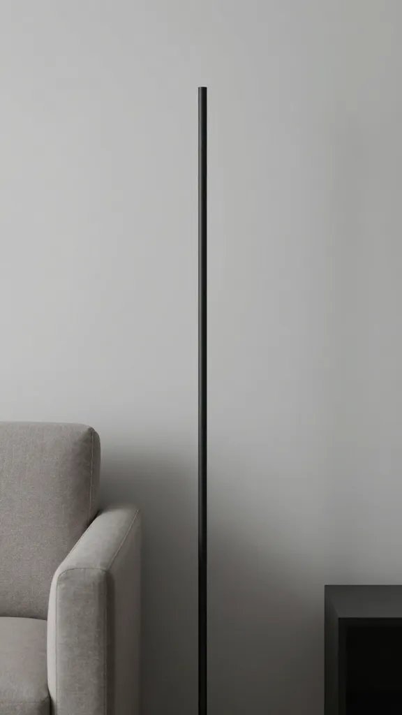 closeup of a narrow, unobtrusive floor lamp beside a slim sofa